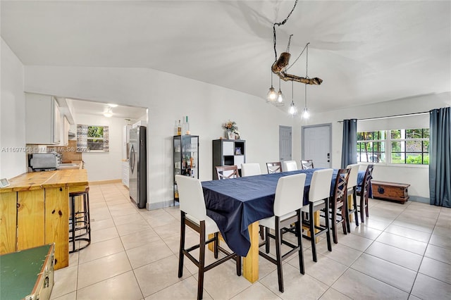 tiled dining area with plenty of natural light and vaulted ceiling