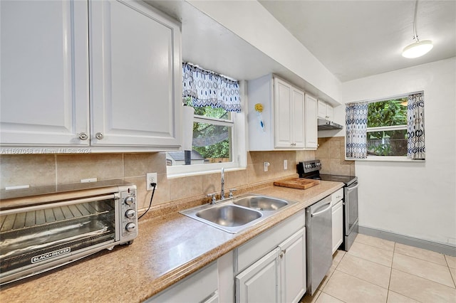 kitchen with tasteful backsplash, sink, white cabinets, and appliances with stainless steel finishes