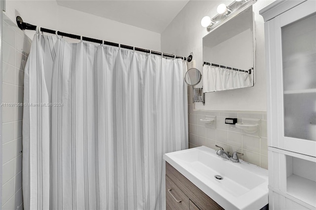 bathroom featuring a shower with curtain, vanity, and tile walls