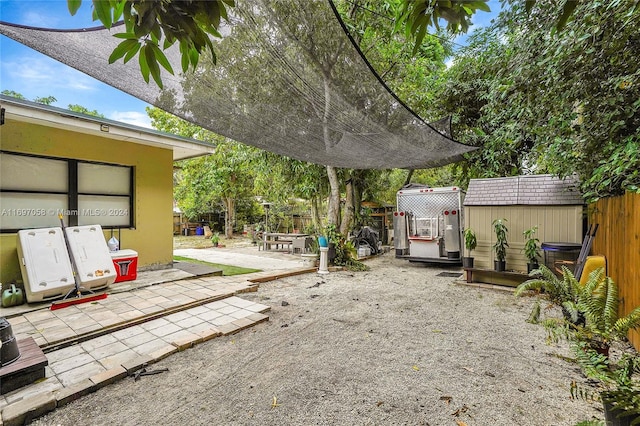 view of yard with a patio and a storage unit