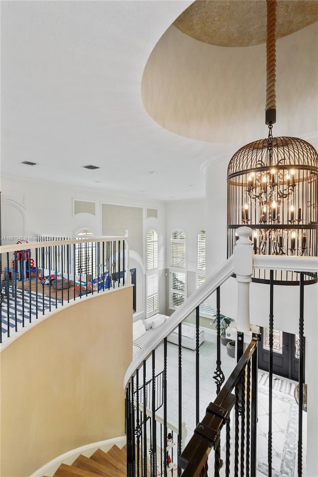 staircase with a notable chandelier