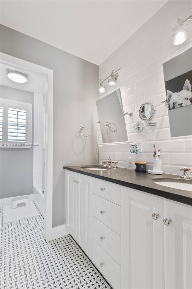 bathroom with vanity, backsplash, and tiled shower / bath