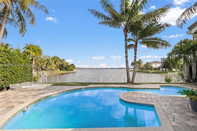 view of swimming pool featuring a patio and a water view