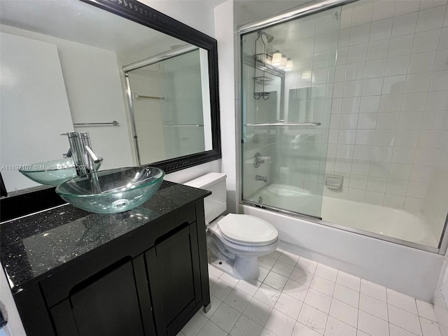 full bathroom featuring tile patterned floors, vanity, toilet, and shower / bath combination with glass door