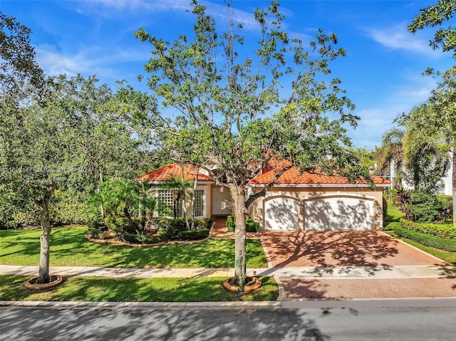 mediterranean / spanish-style home with a front yard and a garage