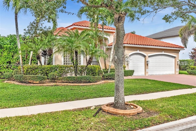 mediterranean / spanish-style home featuring a front yard and a garage