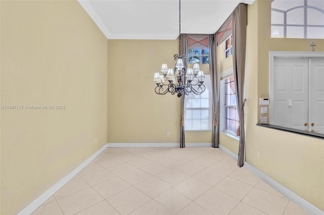 unfurnished room with crown molding and an inviting chandelier