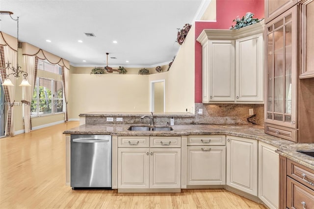 kitchen featuring pendant lighting, dishwasher, light hardwood / wood-style floors, and sink