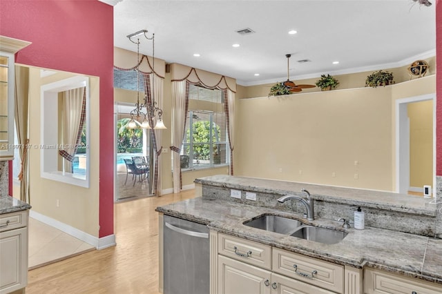 kitchen with dishwasher, sink, light stone counters, light hardwood / wood-style flooring, and pendant lighting