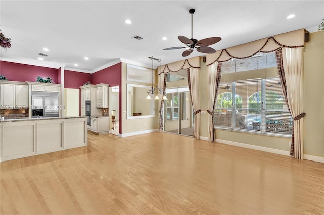 kitchen with white cabinets, light hardwood / wood-style flooring, built in refrigerator, and plenty of natural light