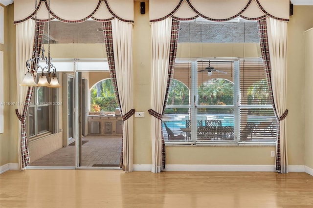 doorway with wood-type flooring and a notable chandelier