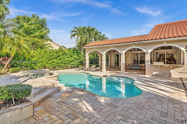 view of swimming pool featuring an in ground hot tub, a bar, a patio, and ceiling fan