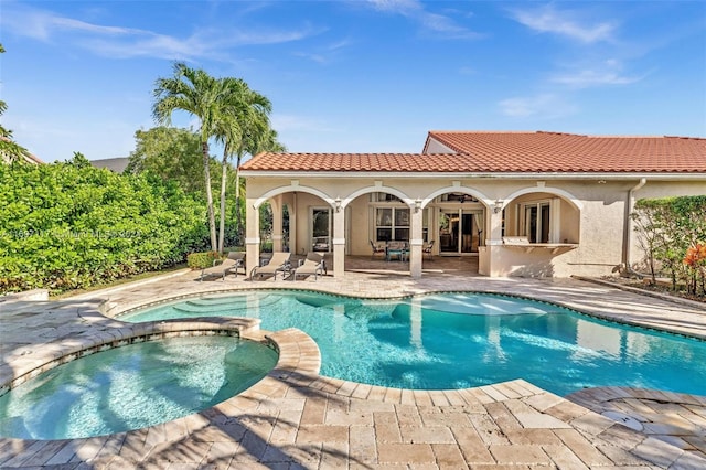 view of pool with a patio area and an in ground hot tub