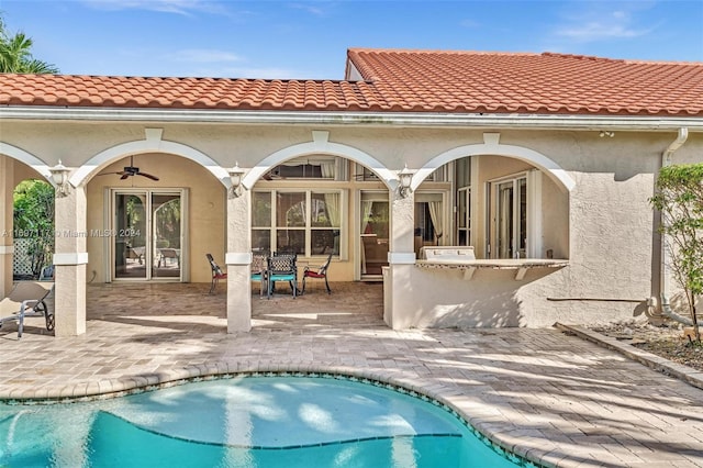 rear view of house with ceiling fan and a patio