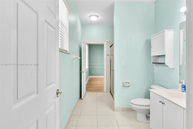 bathroom with tile patterned flooring, vanity, toilet, and an enclosed shower