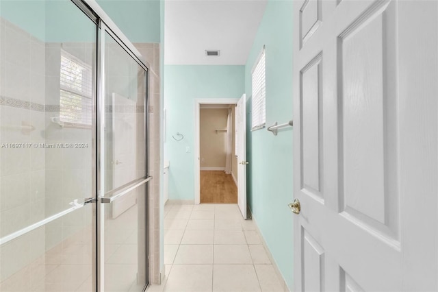 bathroom featuring tile patterned flooring and an enclosed shower