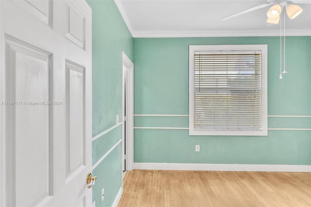 spare room with light wood-type flooring, ceiling fan, and crown molding