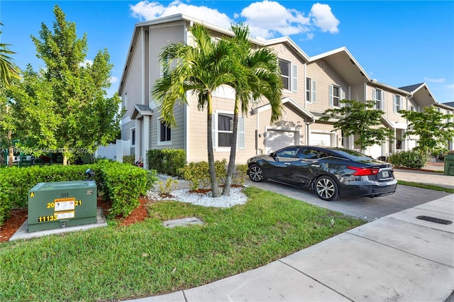 view of property featuring a front lawn and a garage