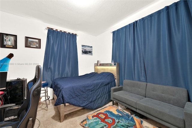 bedroom featuring light carpet and a textured ceiling