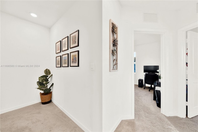 hall with light colored carpet