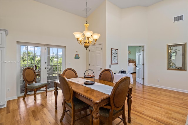 dining room with a chandelier, light hardwood / wood-style floors, and high vaulted ceiling