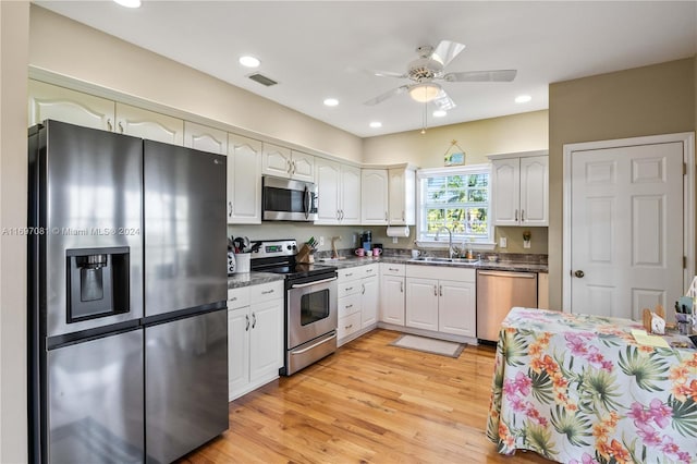 kitchen featuring ceiling fan, sink, light hardwood / wood-style floors, white cabinets, and appliances with stainless steel finishes