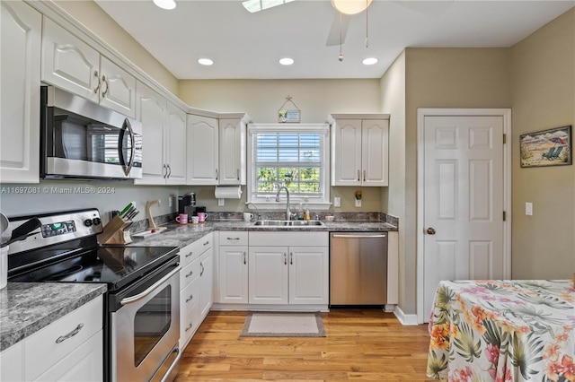 kitchen with white cabinetry, sink, light hardwood / wood-style floors, and appliances with stainless steel finishes