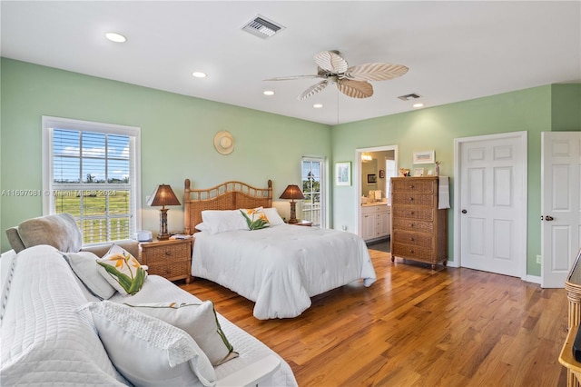 bedroom featuring hardwood / wood-style flooring, ensuite bathroom, and ceiling fan