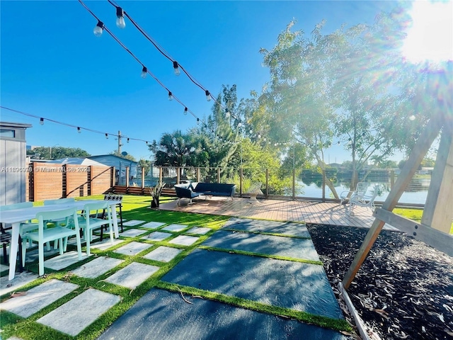 view of yard featuring an outdoor living space, a water view, and a patio