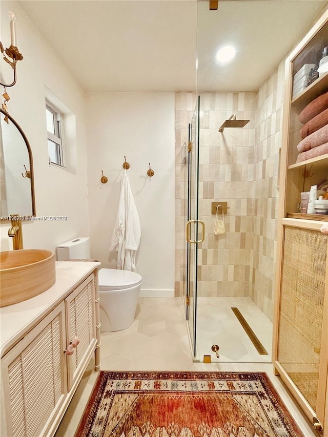 bathroom with tile patterned floors, vanity, toilet, and an enclosed shower