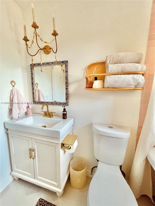 bathroom with vanity, toilet, and an inviting chandelier