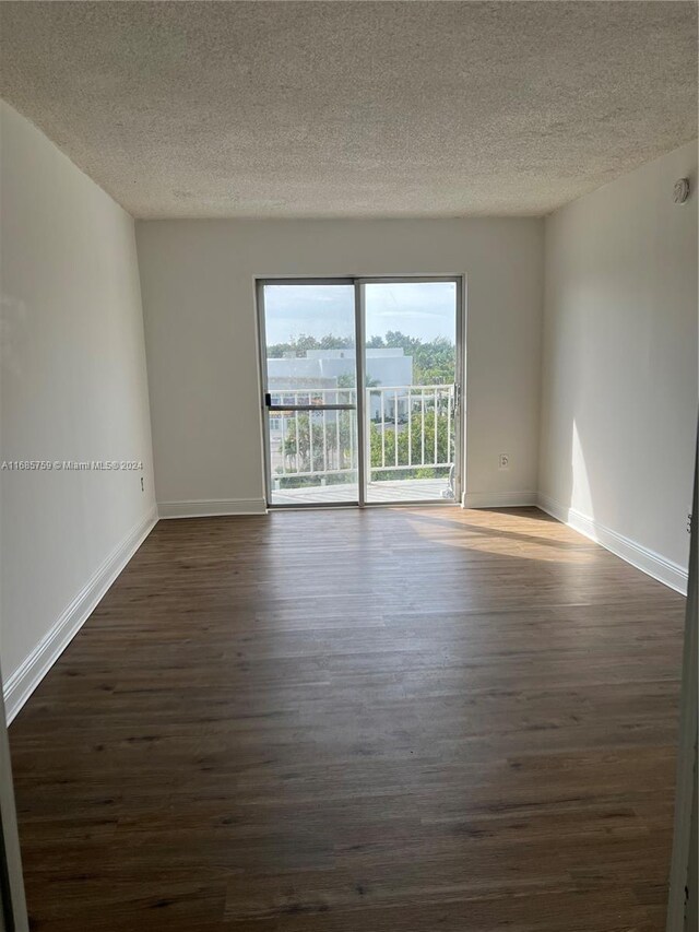 498 NW 165th St Rd Unit D-607, Miami, FL 33169 - empty room featuring dark wood-style floors, a textured ceiling, and baseboards