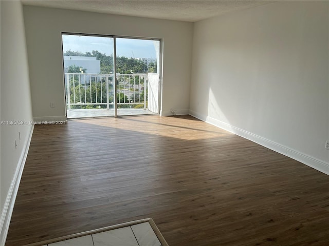 empty room featuring dark hardwood / wood-style flooring and a textured ceiling