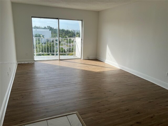 498 NW 165th St Rd Unit D-607, Miami, FL 33169 - spare room featuring wood finished floors, baseboards, and a textured ceiling
