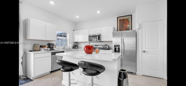 kitchen with white cabinets, a center island, and stainless steel appliances