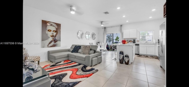 living room with ceiling fan, sink, and light tile patterned floors