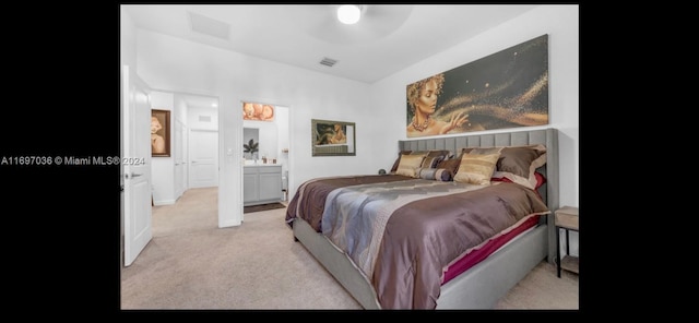 bedroom with light carpet and ensuite bathroom