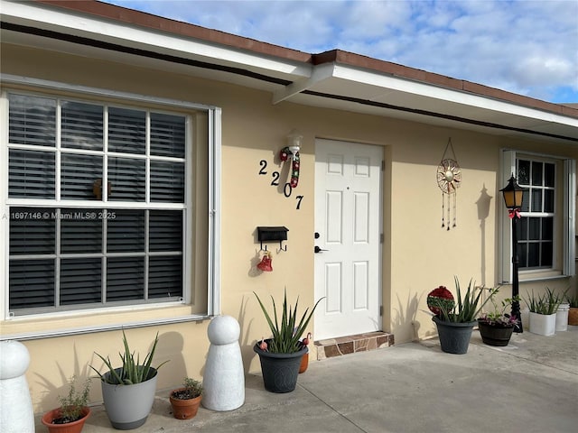 view of exterior entry with a patio area