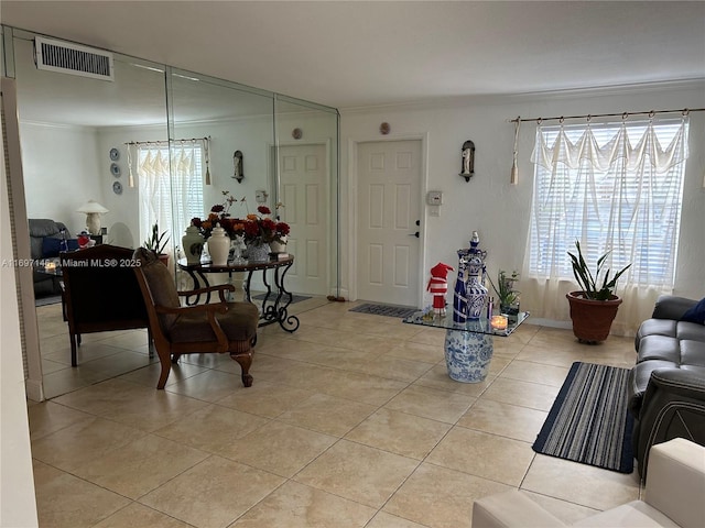 living room with light tile patterned floors and ornamental molding