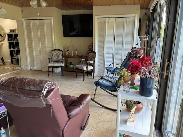 living room with light tile patterned floors and wood ceiling