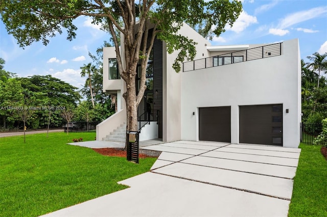 modern home featuring a balcony, a garage, and a front lawn