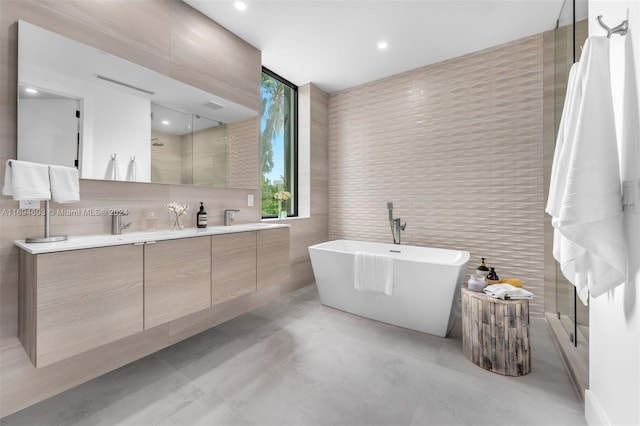 bathroom featuring vanity, plus walk in shower, and tile walls