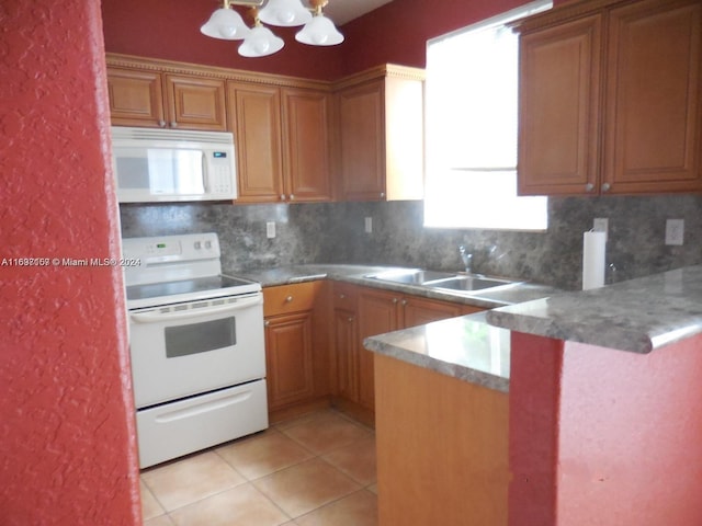 kitchen with kitchen peninsula, backsplash, white appliances, sink, and a chandelier