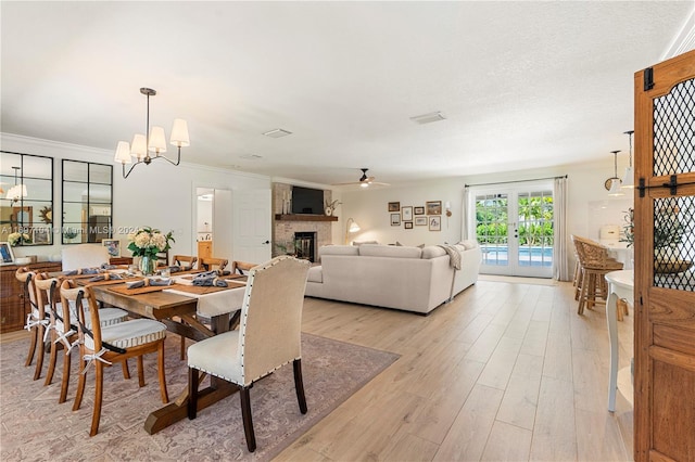 dining room with french doors, ceiling fan with notable chandelier, light hardwood / wood-style floors, and crown molding