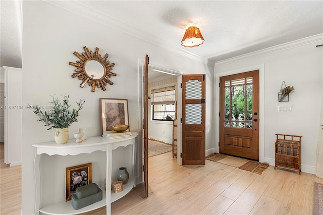 foyer with a textured ceiling, light hardwood / wood-style flooring, and crown molding