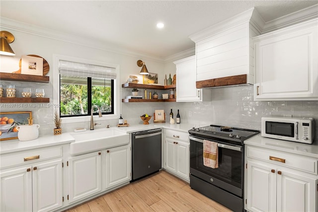 kitchen featuring white cabinetry, electric range, sink, stainless steel dishwasher, and light wood-type flooring