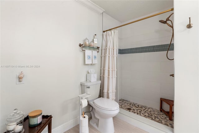 bathroom featuring tile patterned flooring, toilet, and curtained shower