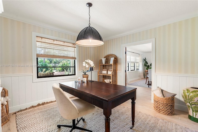 office space featuring a textured ceiling, light hardwood / wood-style floors, and ornamental molding