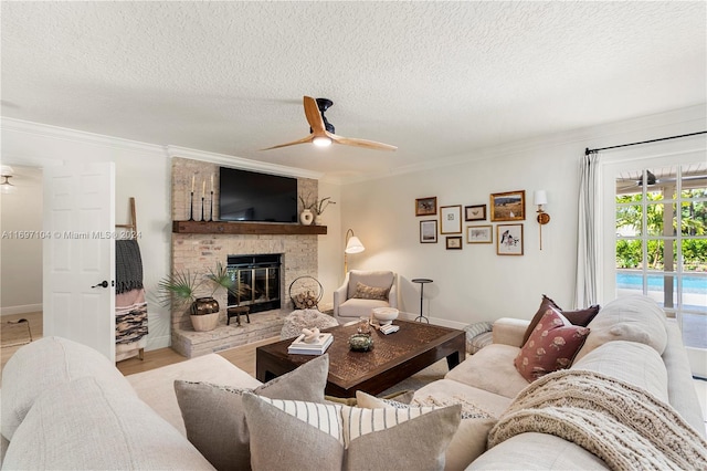 living room with a textured ceiling, ceiling fan, crown molding, a fireplace, and light hardwood / wood-style floors