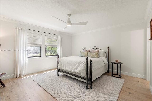 bedroom with ceiling fan, light hardwood / wood-style floors, ornamental molding, and a textured ceiling